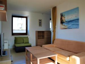 a living room with a couch and a table at Apartament Nadmorski in Sarbinowo