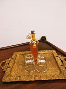 a bottle of honey and two glasses on a tray at Superior Apartment in Korinthos +17 photos
