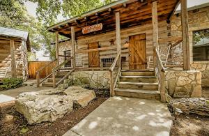 una cabaña de madera con escaleras y un cartel en ella en The Kendall en Boerne