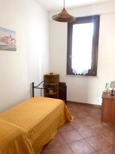 um quarto com uma cama amarela e uma janela em Posidonia Apartments em Marsala