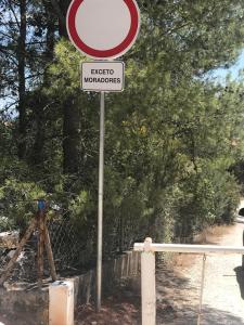 a red and white sign on top of a road at Casa do Farol da Arrábida in Portinho da Arrábida