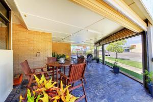 a patio area with a table and chairs at Raintree Motel in Townsville