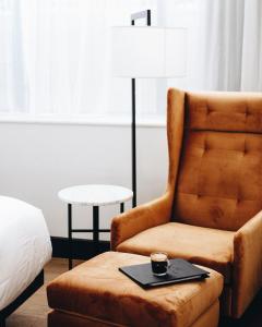 a bedroom with a chair and a cup of coffee at Hotel Place D'Armes in Montreal