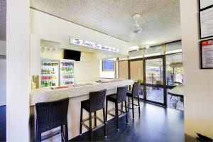 a restaurant with a bar with stools at Raintree Motel in Townsville