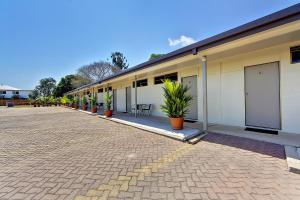 un edificio con macetas al costado. en Raintree Motel en Townsville