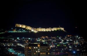 a view of a city at night with a castle at Elit Hotel in Derbent