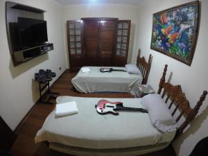 En eller flere senger på et rom på Confortável casa de madeira