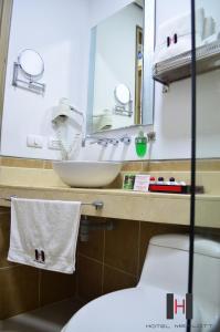 a bathroom with a sink and a toilet and a mirror at Hotel Merlott 70 in Medellín