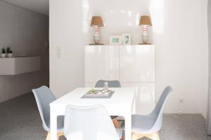 ein weißes Esszimmer mit einem weißen Tisch und Stühlen in der Unterkunft dreamlike APARTMENT in Oberndorf