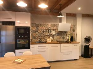 uma cozinha com electrodomésticos brancos e uma mesa de madeira em La casa de Lucas y Alex em Ponferrada