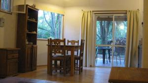 cocina con mesa y sillas y comedor en Manantial Hostería & Cabañas en Nono