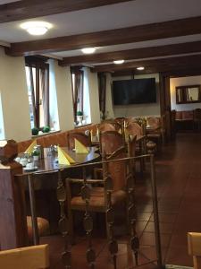 a dining room with a table and chairs and a television at Hotel City Faber in Worms