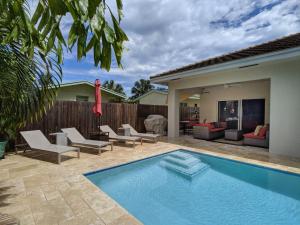 una piscina con tumbonas y una casa en Coral Reef Villa, en Fort Lauderdale