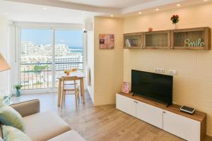 een woonkamer met een grote flatscreen-tv bij Benalmadena Seafront Top Floor Studio in Benalmádena