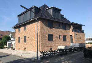 a large brick building with a black roof at Apartment Meine in Meine