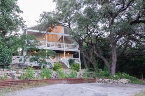 duży biały dom z drzewem i schodami w obiekcie Remodeled Historic Lakefront Gem Overlooking Lake Travis and Jones Brothers Park *Great for Families and Groups* w mieście Jonestown