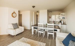a kitchen and living room with a table and chairs at Voir la Mer - Blouberg Beach in Bloubergstrand