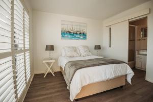 une chambre avec un lit et un tableau au mur dans l'établissement Voir la Mer - Blouberg Beach, à Bloubergstrand 9 autres photos