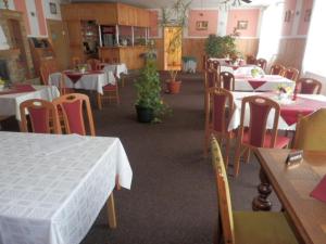 a restaurant with tables, chairs, and tables in it at Penzion u Zámku in Habartov