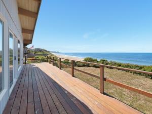 a wooden porch with a view of the beach at Ocean Waves in Gleneden Beach