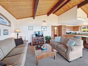 a living room with two couches and a table at Ocean Waves in Gleneden Beach