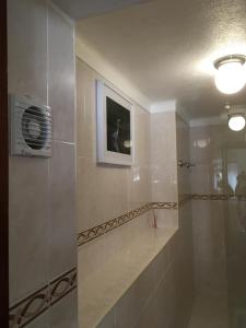 a bathroom with a glass shower with a fan at Casa da Avó Tina - Apartamento in Castelo de Vide