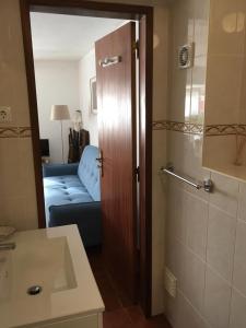 a bathroom with a door to a living room with a couch at Casa da Avó Tina - Apartamento in Castelo de Vide