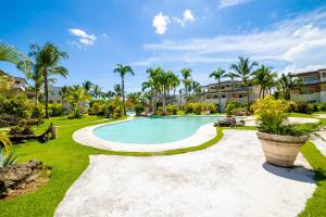a swimming pool in a yard with palm trees at Casa Caribe Appartamento Attico in Bayahibe