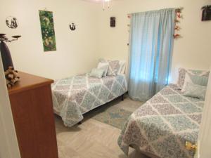 1 dormitorio con 2 camas, vestidor y ventana en A Touch of Madagascar in Fort Walton Beach with HEATING POOL en Fort Walton Beach