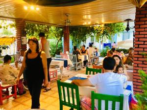 Side Erenler Hotel في سيدي: امرأة تمر في مطعم مع مجموعة من الناس