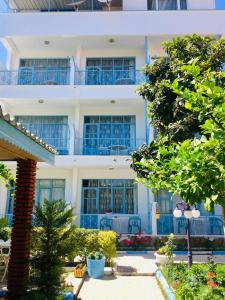 a building with blue windows and a tree at Side Erenler Hotel in Side