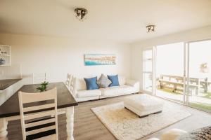 un salon avec une table et un canapé dans l'établissement Voir la Mer - Blouberg Beach, à Bloubergstrand
