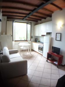 a living room with a white couch and a kitchen at Appartamento Luisa in Parma