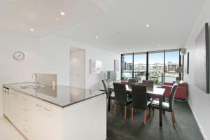 a kitchen and dining room with a table and chairs at Docklands Private Collection - NEWQUAY in Melbourne