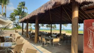 a restaurant on the beach with tables and chairs at Condominio Mediterraneo - Iberostate in Praia do Forte