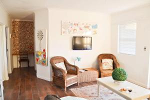 a living room with two chairs and a tv at Aintree Farm Cottage in Langebaan