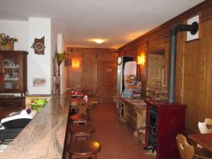 una cocina con armarios de madera y una barra con taburetes en Meublè Blue House, en Auronzo di Cadore