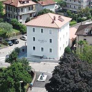 un bâtiment blanc avec un toit rouge dans une ville dans l'établissement Locanda Marco, à Bellinzone