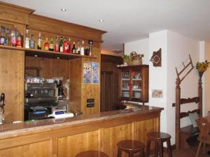 a bar in a restaurant with wooden cabinets and bar stools at Meublè Blue House in Auronzo di Cadore