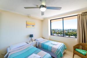 
a bedroom with two beds and a window at Burgess @ Kings Beach Apartments in Caloundra
