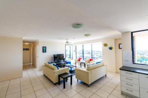 
a living room filled with furniture and a tv at Burgess @ Kings Beach Apartments in Caloundra
