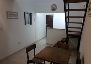 a dining room with a table and a spiral staircase at Dpto Low Cost Terraza Alem Costanera in Gualeguaychú