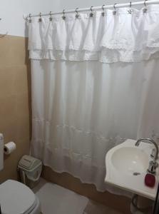 a bathroom with a white shower curtain and a sink at Dpto Low Cost Terraza Alem Costanera in Gualeguaychú +16 photos