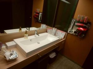 uma casa de banho com um lavatório branco e um espelho. em Hotel PLAISIR (Adult Only) em Hiroshima