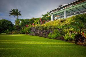a green lawn in front of a building at Affordable Luxury on One Acre in Kailua-Kona