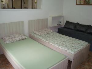 Duas camas num pequeno quarto com um sofá em Apart Marcelo - Studio Copacabana no Rio de Janeiro