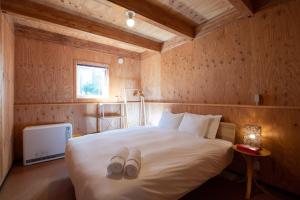 1 dormitorio con 1 cama con 2 zapatillas en Midori, en Niseko