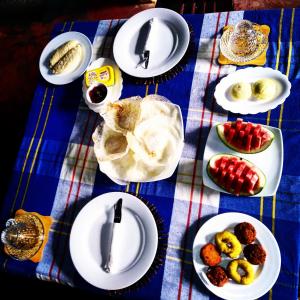 錫吉里亞的住宿－Manju Homestay，一张桌子,上面有盘子,放在蓝白桌布上