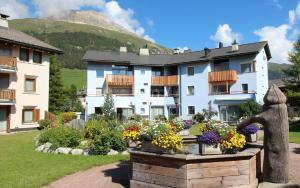 ein großes weißes Gebäude mit Blumen in einem Garten in der Unterkunft Dalia E12 in Celerina