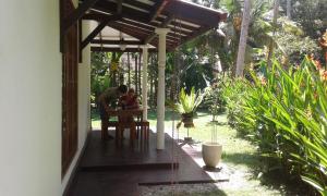 a man sitting at a table on a porch at Bird Villa in Galle